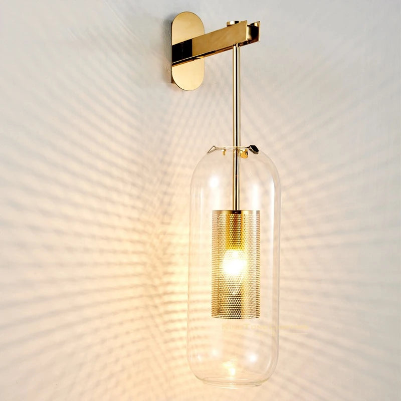 Velada · aplique de pared en cristal y latón dorado sobre mesita de noche